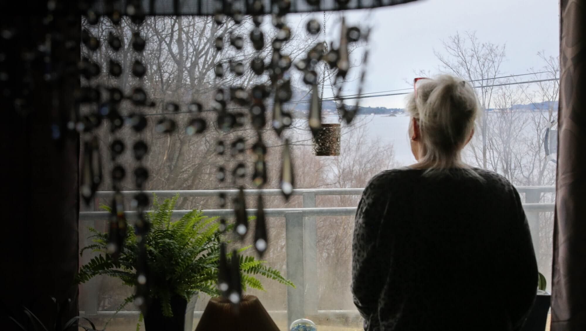 Mor til rusmisbruker ser ut av vinduet